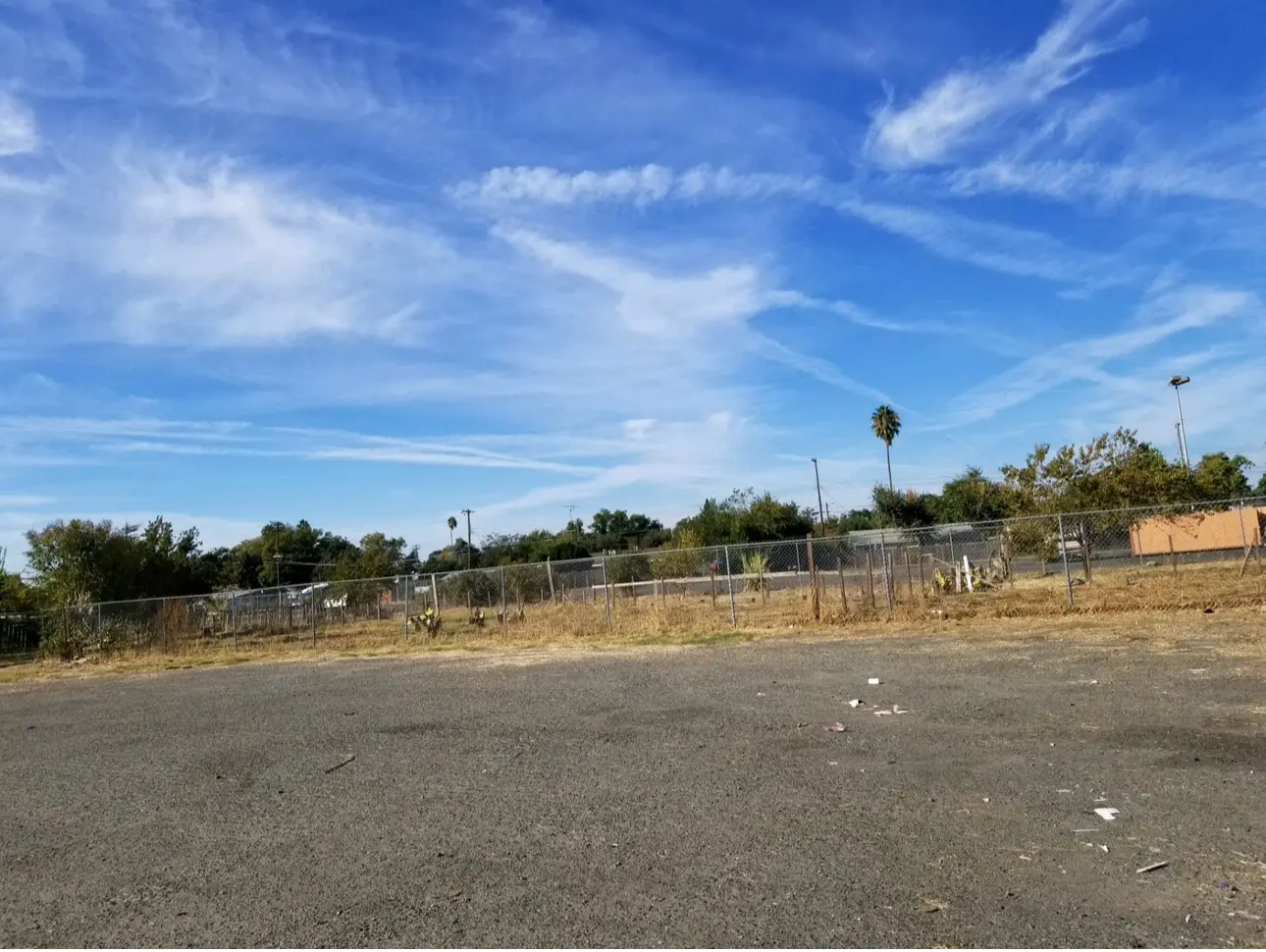 Empty lot with blue sky and clouds.